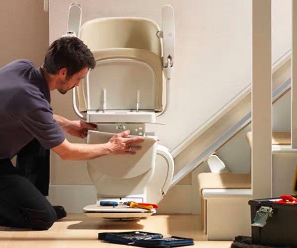 Stairlift repair engineer fixing a stairlift seat in Ireland